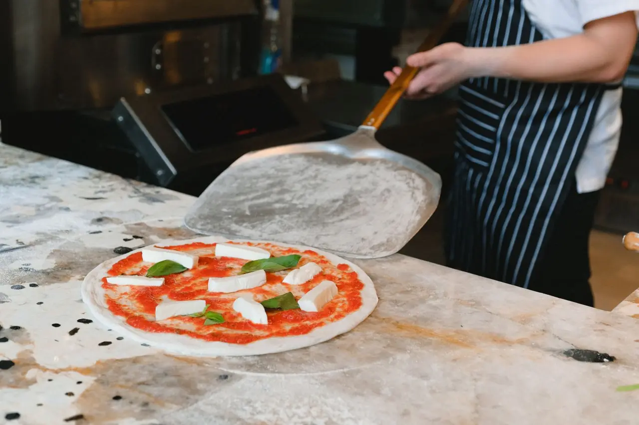 Uncooked pizza with fresh basil